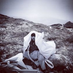 Portrait of man covered with plastic on mountain during winter