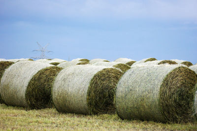 Hay bales on field against sky