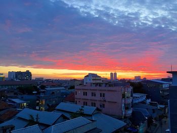 Buildings against cloudy sky at sunset