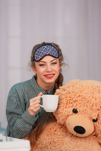 Portrait of smiling woman holding coffee cup