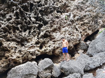 Rear view of woman standing on rock formation