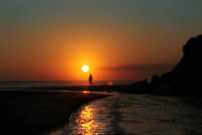 Scenic view of sea against orange sky