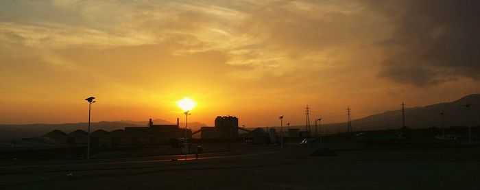 Vehicles on road at sunset