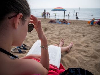 Girl reading book at beach