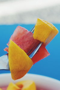 Close-up of yellow ice cream against blue sky