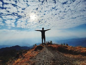 Full length of man standing on mountain against sky