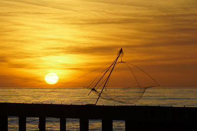 Silhouette of sea against orange sky