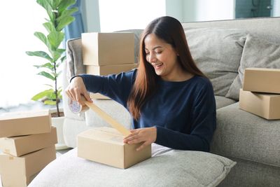 Portrait of young woman sitting on sofa at home