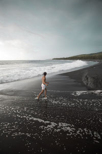 Full length of boy on beach against sky