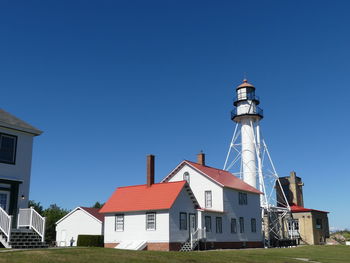 Lighthouse by building against clear sky, whitefish point lighthouse