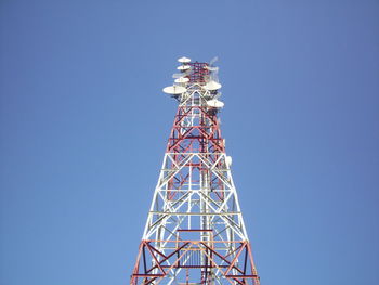 Low angle view of communications tower against blue sky