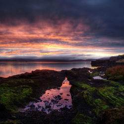 Reflection of clouds in sea at sunset