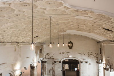 Low angle view of illuminated chandelier hanging in building