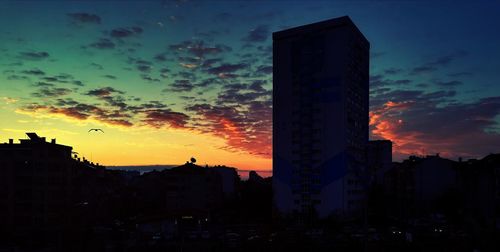 Low angle view of silhouette cityscape against sky during sunset