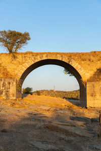 Arch bridge against clear blue sky