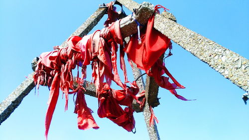 Low angle view of clothes hanging against clear blue sky