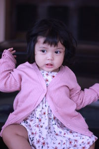 Portrait of cute girl sitting outdoors