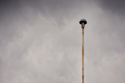 Low angle view of street light against cloudy sky