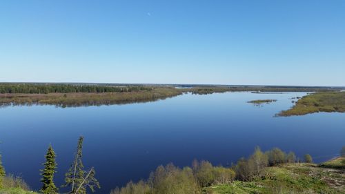 Scenic view of lake against clear blue sky
