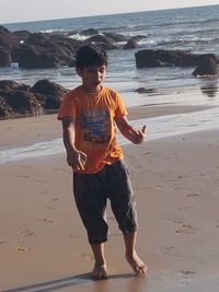 Full length of boy standing on beach
