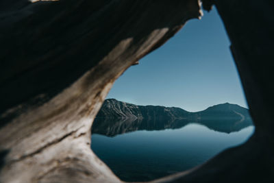 Scenic view of lake by mountains against sky