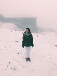 Portrait of woman standing on snow covered land