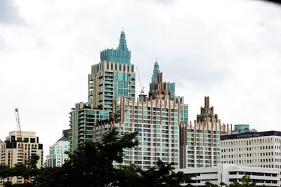 Buildings in city against cloudy sky