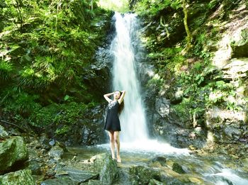 Full length of waterfall on rock in forest