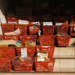 Objects in red crates arranged on steps for sale