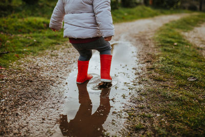 Low section of man walking in puddle
