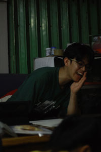 Portrait of young woman sitting on table