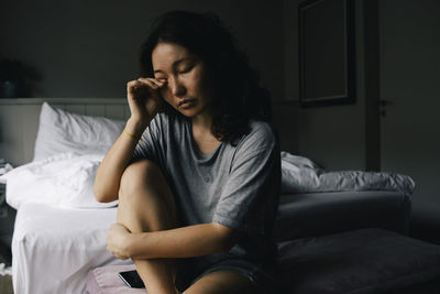 Mentally ill woman crying alone in bedroom at home