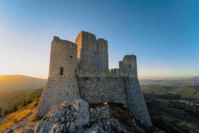 Castle on mountain against blue sky