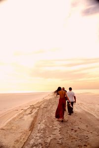 Silhouette of woman standing on beach at sunset