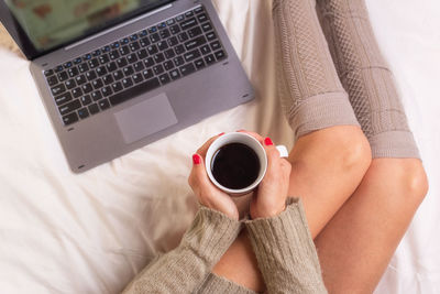 High angle view of woman holding coffee cup