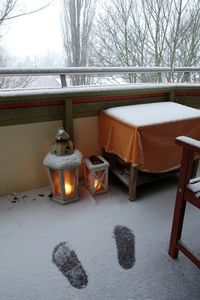 Tea light and trees in snow