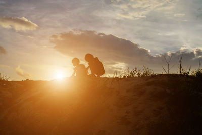 Silhouette couple against sky during sunset