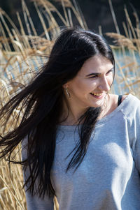 Smiling young woman with long hair looking away
