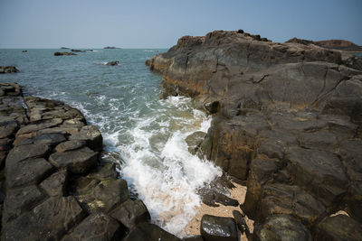 Scenic view of rocks in sea against clear sky