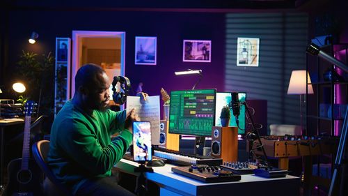 Rear view of woman using mobile phone while sitting at airport