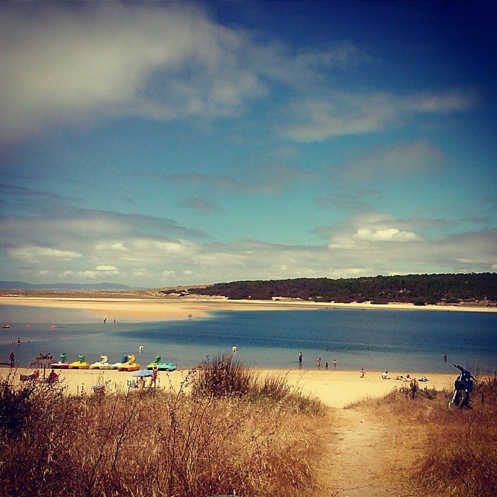 water, sky, beach, tranquil scene, tranquility, scenics, sea, sand, shore, cloud - sky, beauty in nature, nature, cloud, incidental people, idyllic, lake, outdoors, grass, coastline, transportation