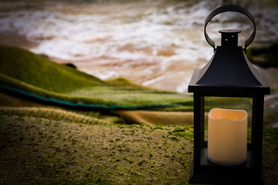 Close-up of electric lamp by sea