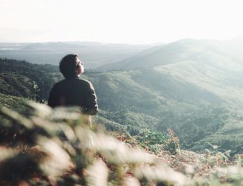 Rear view of man on landscape against sky
