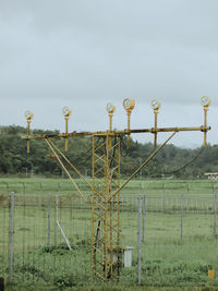 Fence on field against sky