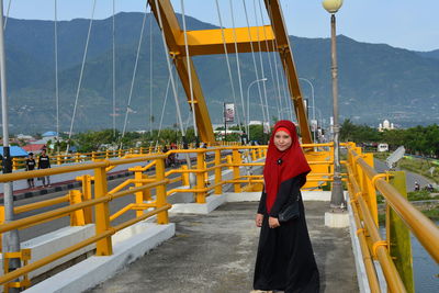 Portrait of woman standing against yellow sky