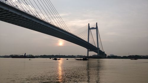 View of bridge over river at sunset