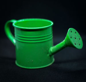 Close-up of green drink on table against black background