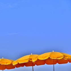 Low angle view of ferris wheel against blue sky