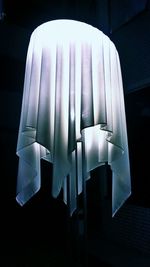 Low angle view of white fabric on pendant light in darkroom