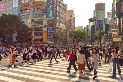 Group of people walking on road in city